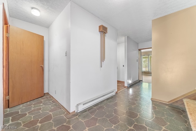 hall with a textured ceiling and a baseboard heating unit