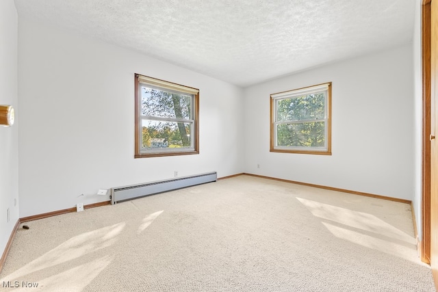 spare room featuring a textured ceiling, a wealth of natural light, and baseboard heating