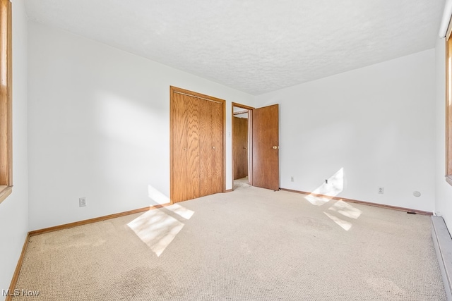 unfurnished bedroom with a textured ceiling and carpet flooring