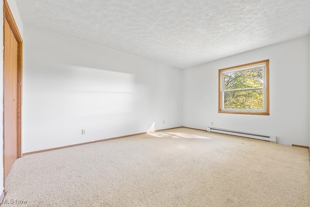 spare room featuring a textured ceiling, light colored carpet, and a baseboard radiator