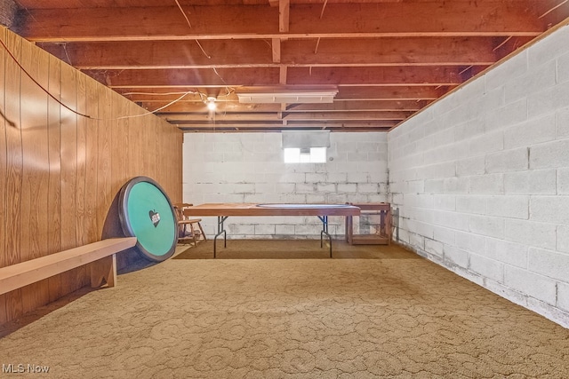 basement with wood walls and carpet flooring