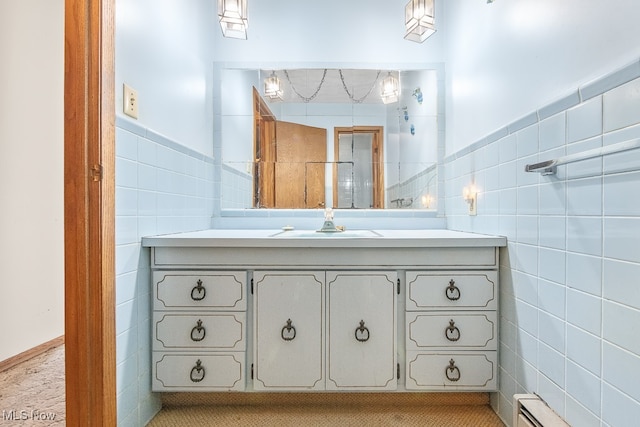 bathroom featuring vanity, a baseboard heating unit, and tile walls