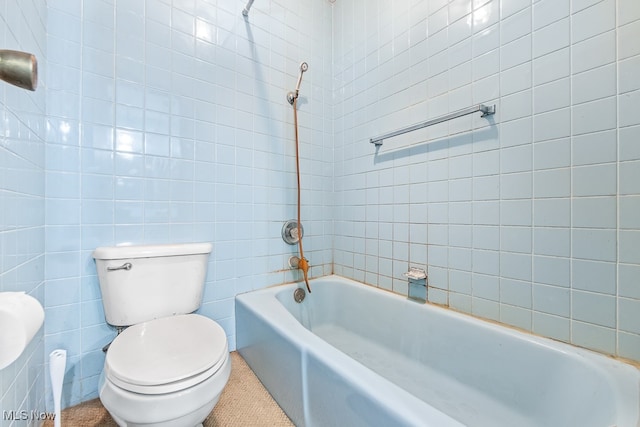 bathroom with toilet, tiled shower / bath, tile walls, and tile patterned flooring