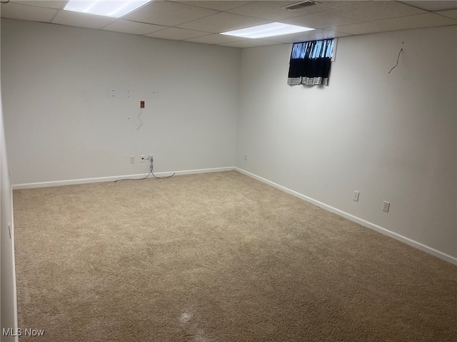 basement featuring a paneled ceiling and carpet floors