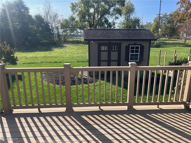 wooden terrace featuring a lawn and an outdoor structure