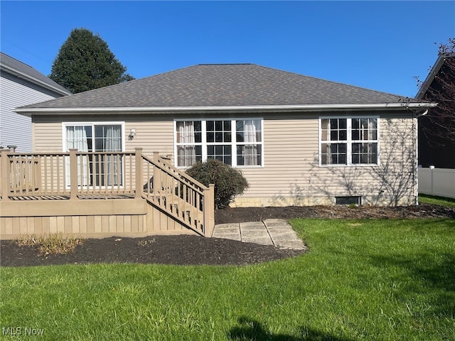 rear view of property with a wooden deck and a lawn