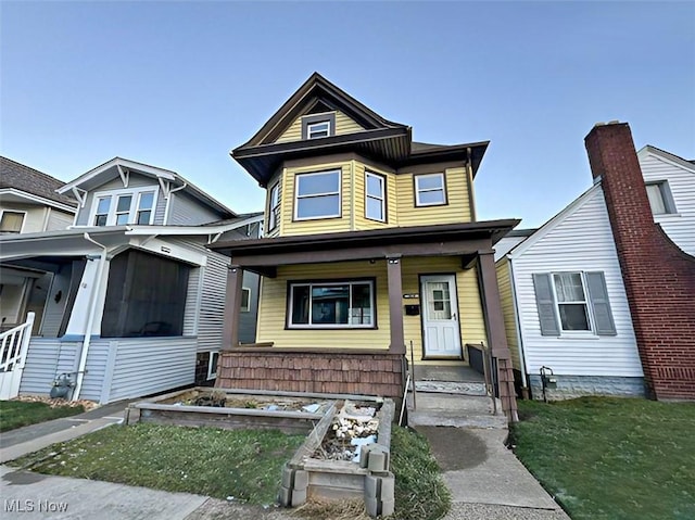 view of front of property featuring a porch and a vegetable garden