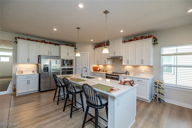 kitchen featuring sink, white cabinetry, stainless steel appliances, and plenty of natural light