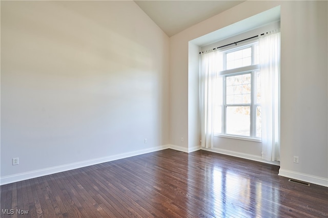 empty room with lofted ceiling and dark wood-type flooring