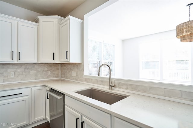 kitchen with sink, backsplash, hanging light fixtures, white cabinetry, and stainless steel dishwasher