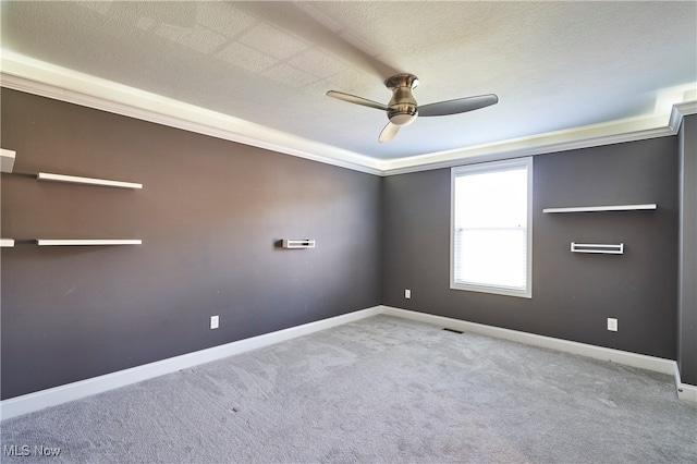 carpeted spare room with crown molding, a textured ceiling, and ceiling fan