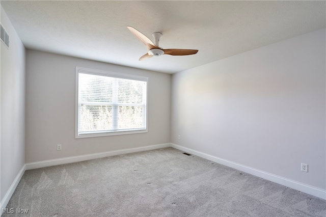 carpeted spare room featuring ceiling fan