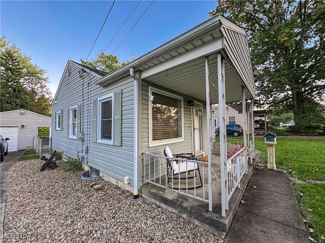 view of front of house featuring an outdoor structure, a garage, and a front lawn