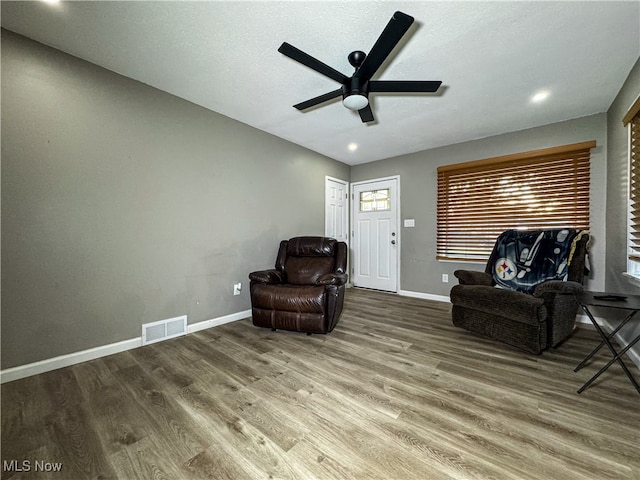 living area with hardwood / wood-style flooring and ceiling fan