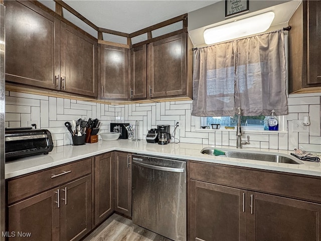 kitchen featuring dishwasher, decorative backsplash, dark brown cabinets, sink, and light hardwood / wood-style floors