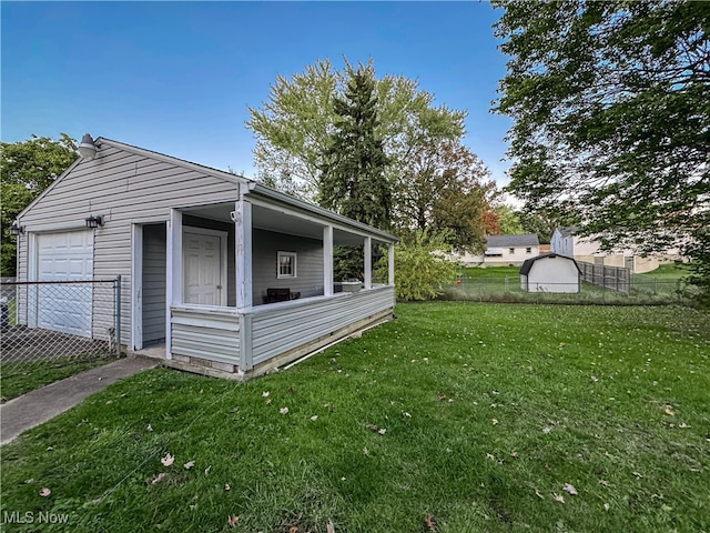 view of side of home featuring a yard, an outbuilding, and a garage