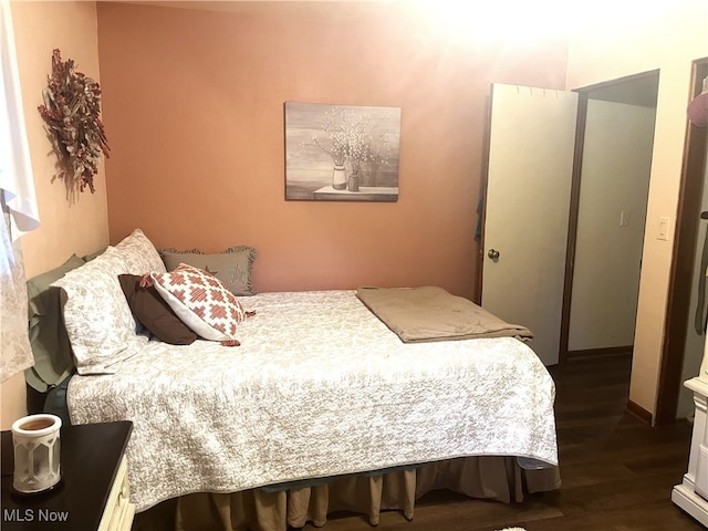 bedroom with dark hardwood / wood-style floors