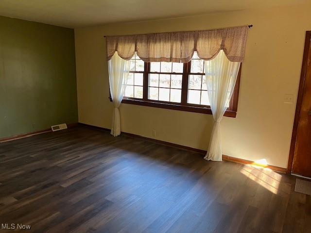 spare room featuring dark hardwood / wood-style floors