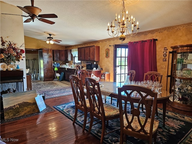 dining area featuring dark hardwood / wood-style floors, a textured ceiling, and ceiling fan with notable chandelier