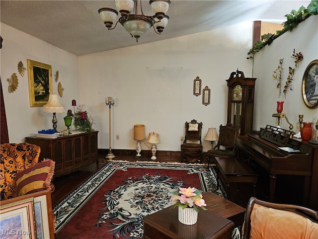 sitting room featuring hardwood / wood-style floors, a notable chandelier, and a textured ceiling