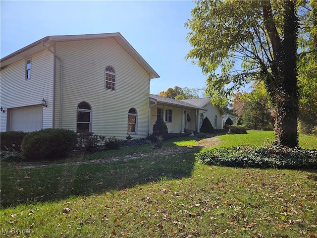 view of home's exterior featuring a yard and a garage