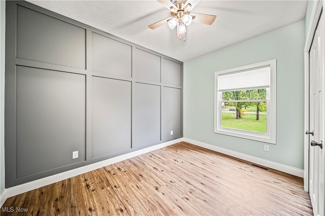 unfurnished bedroom with ceiling fan, light wood-type flooring, and a textured ceiling