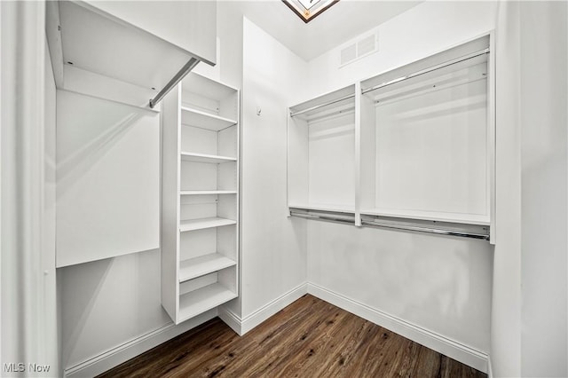 spacious closet featuring dark hardwood / wood-style flooring