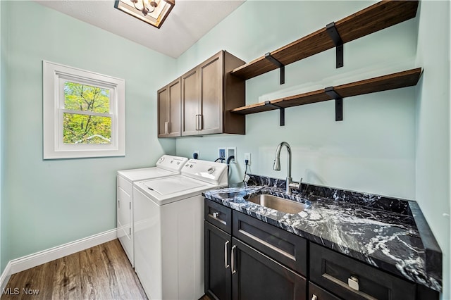 laundry area with independent washer and dryer, sink, cabinets, and light hardwood / wood-style floors