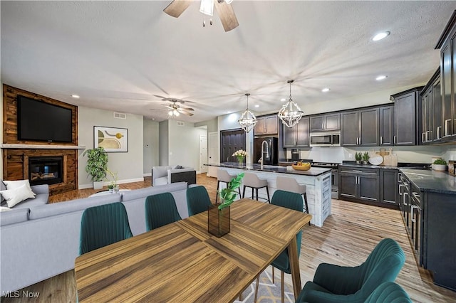 dining room with a chandelier, a textured ceiling, light hardwood / wood-style floors, and sink