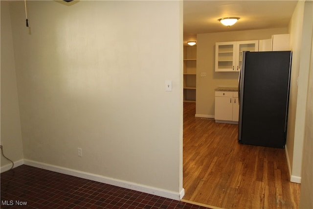 kitchen featuring white cabinets, dark hardwood / wood-style floors, and stainless steel refrigerator