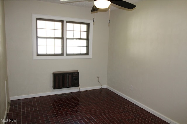 unfurnished room featuring dark tile patterned flooring and ceiling fan