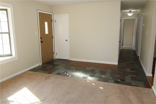 entryway with dark carpet