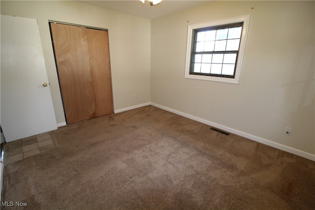 unfurnished bedroom featuring light carpet and a closet