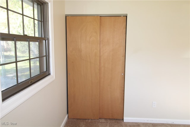 unfurnished bedroom featuring light carpet and a closet