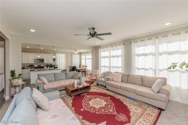 living room featuring light colored carpet and ceiling fan