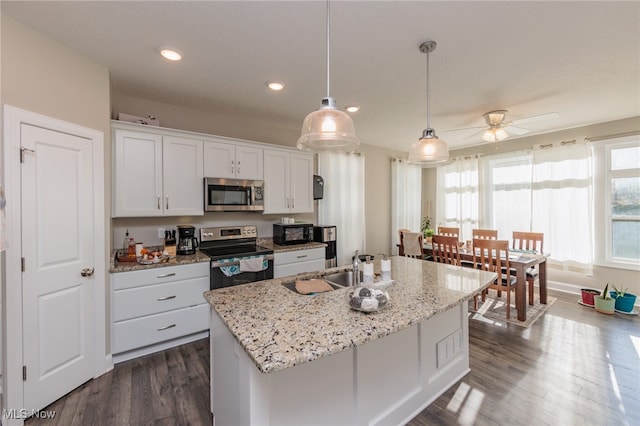 kitchen with a kitchen island with sink, stainless steel appliances, pendant lighting, white cabinets, and ceiling fan