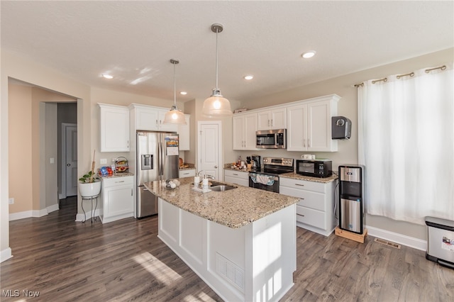 kitchen with a center island with sink, appliances with stainless steel finishes, white cabinets, and dark hardwood / wood-style flooring