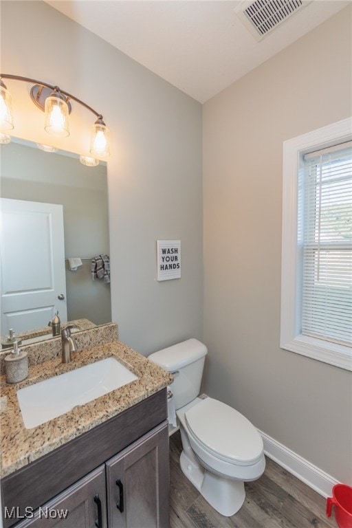 bathroom featuring toilet, hardwood / wood-style flooring, and vanity