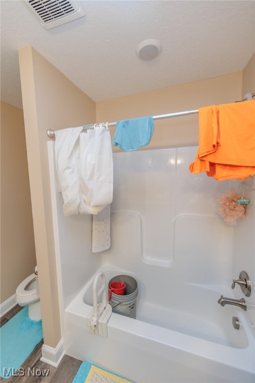 bathroom featuring hardwood / wood-style floors, shower / tub combo with curtain, and toilet