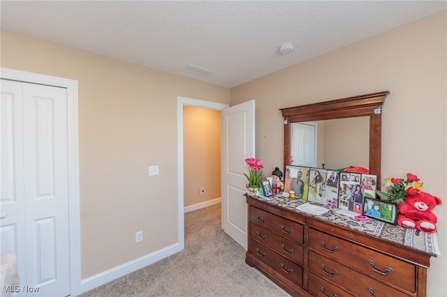 bedroom with light carpet and a closet