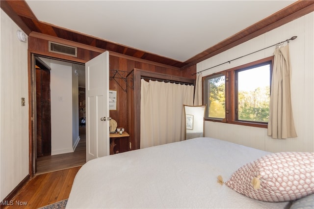 bedroom featuring wood walls and hardwood / wood-style floors