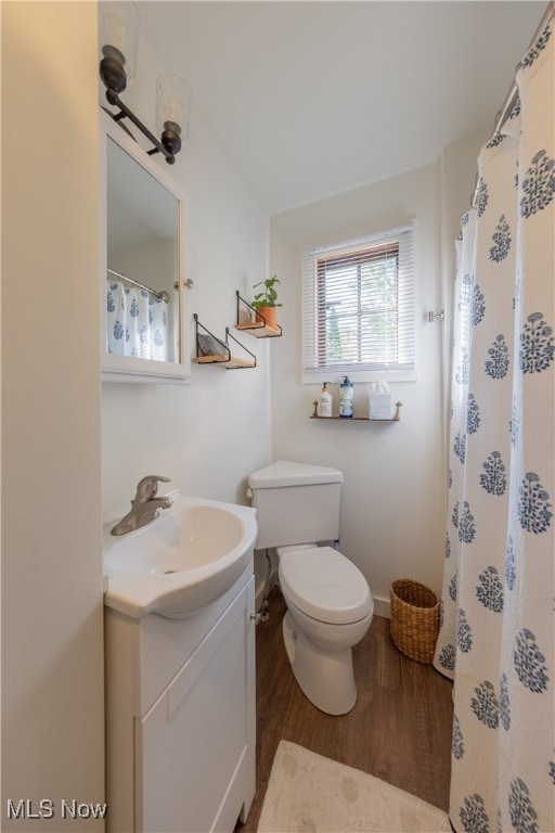 bathroom with vanity, toilet, and hardwood / wood-style floors