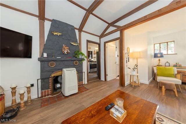 living room featuring lofted ceiling, a fireplace, and wood-type flooring