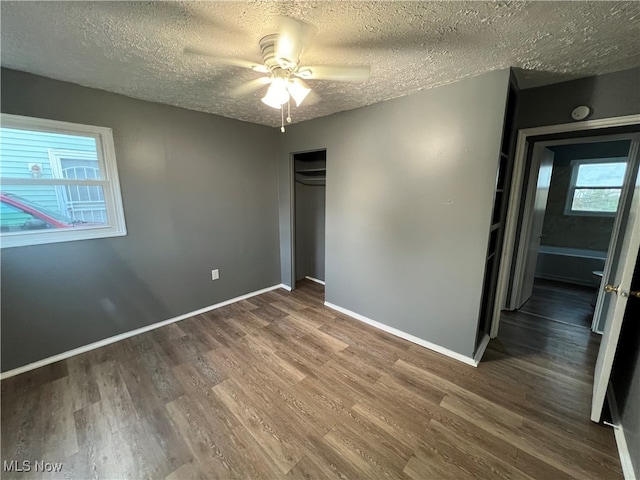 unfurnished bedroom with a closet, hardwood / wood-style floors, a textured ceiling, and ceiling fan