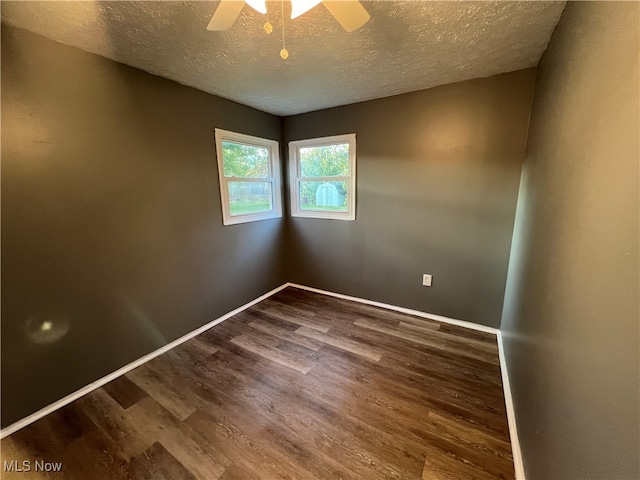 empty room with dark wood-type flooring, a textured ceiling, and ceiling fan