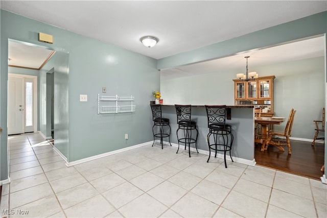 kitchen featuring a kitchen bar, hanging light fixtures, a notable chandelier, and kitchen peninsula