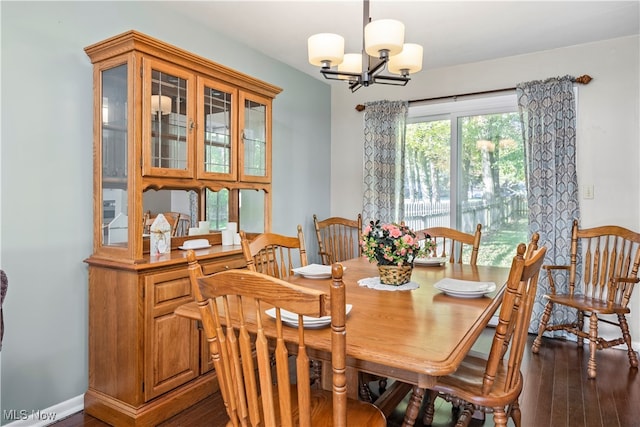 dining space featuring an inviting chandelier and dark wood-type flooring