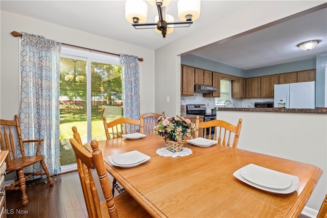 dining space with a notable chandelier and dark hardwood / wood-style flooring