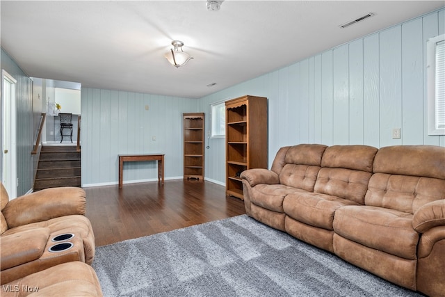 living room featuring dark hardwood / wood-style floors and wooden walls