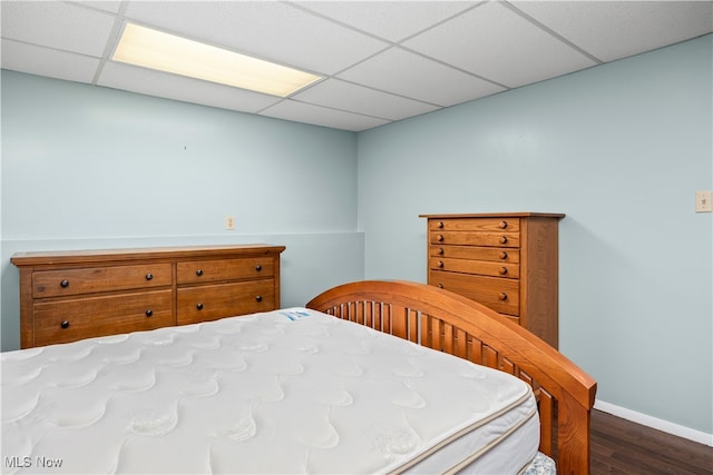 bedroom with dark wood-type flooring and a drop ceiling